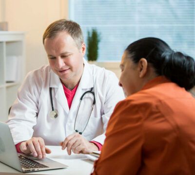 Male doctor reviewing medical paperwork with a female patient