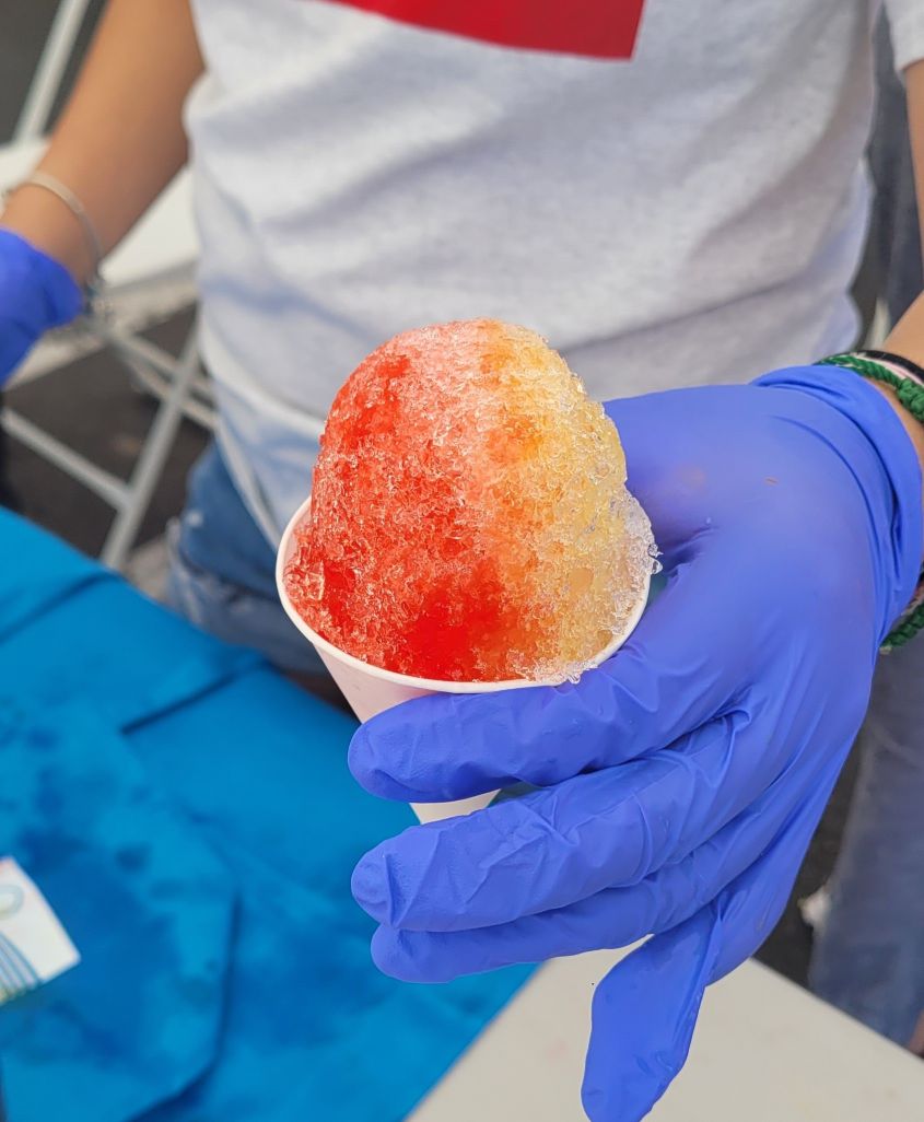 Volunteer handing out a snow cone at a health fair