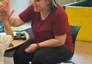 Ary Snell, an ABA program therapist, gives praise to a Day Program client for completing a task. 