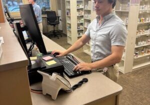 Chase King, a recent graduate of the Ambulatory Care Pharmacy Residency, looks up prescription information at the Unify Community Health, Northeast Community Center Pharmacy in Spokane. 