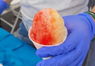 Volunteer handing out a snow cone at a health fair