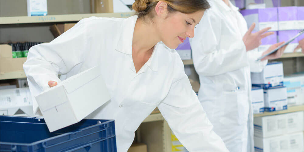Pharmacist putting medication in a transportation box