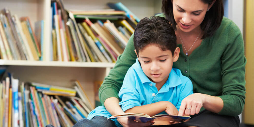 Mother and son reading a book in a library